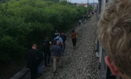 Treno fermo i pendolari si incamminano lungo i binari