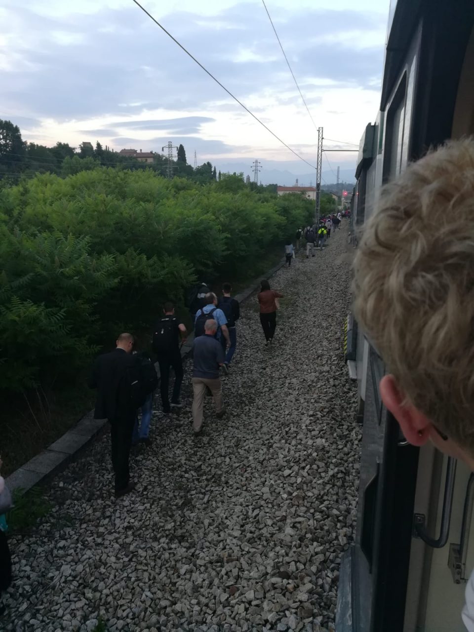 Treno fermo i pendolari si incamminano lungo i binari